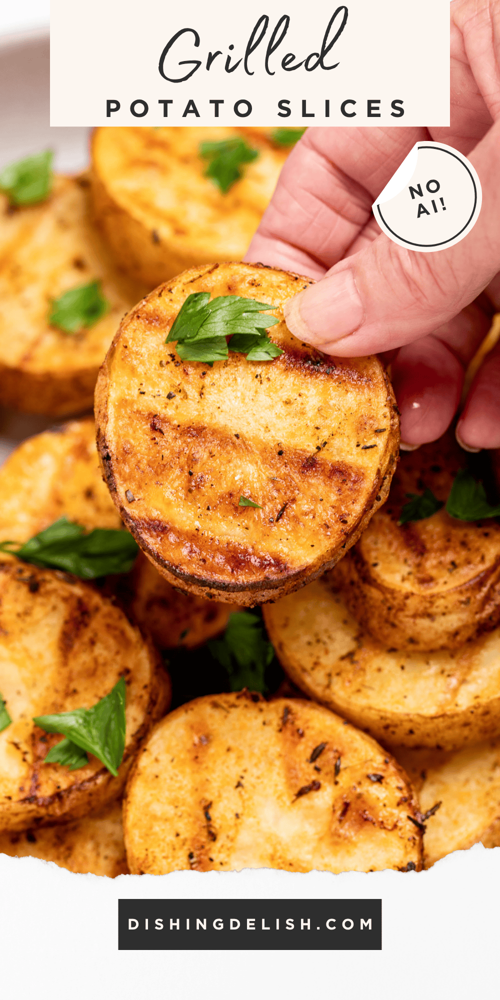 Pinterest pin with a serving bowl with grilled potato slices topped with chopped fresh parsley, and a hand holding one up. The potato slices have nice grill marks.