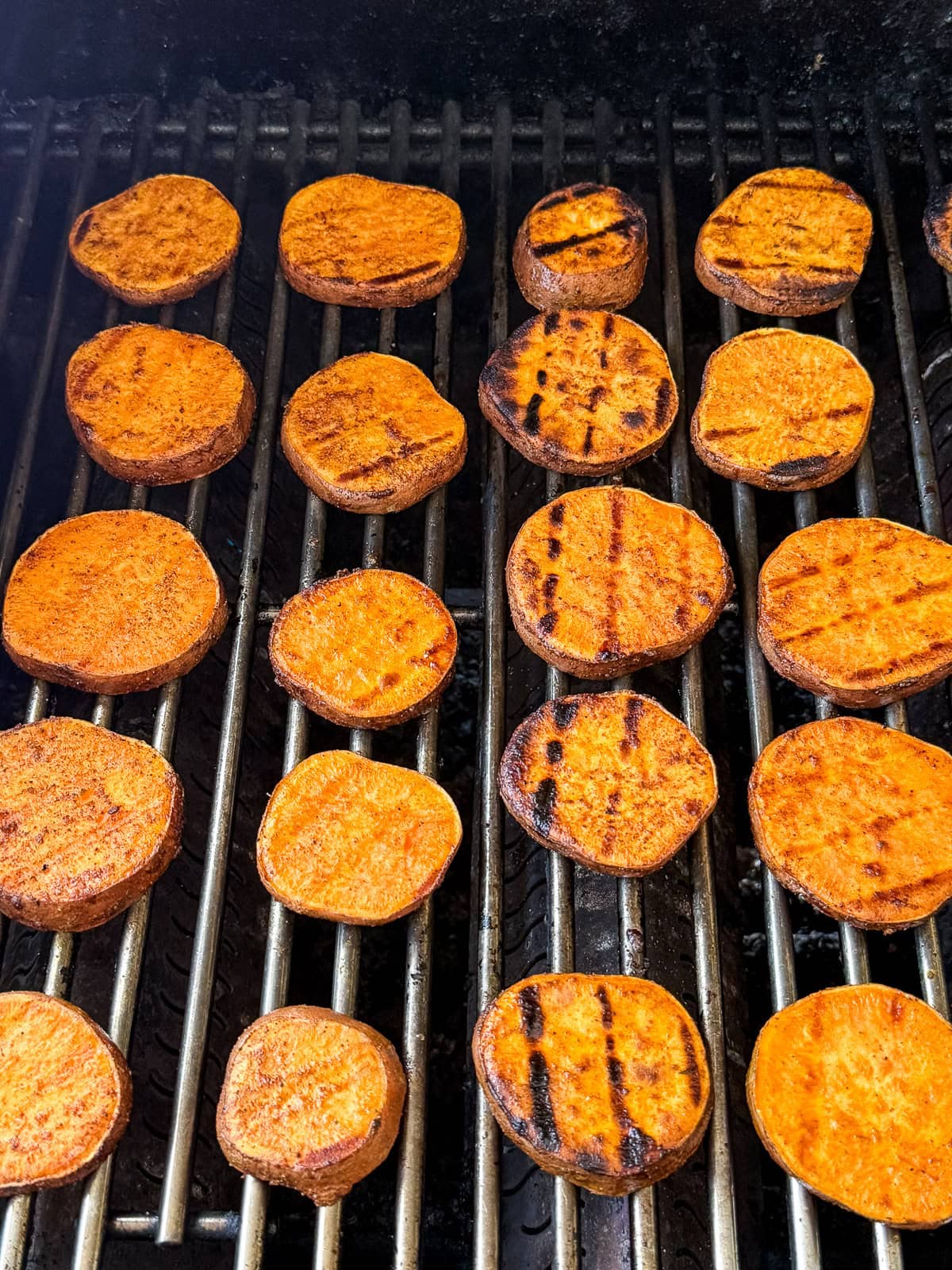 Sweet potato slices on a grill while cooking.