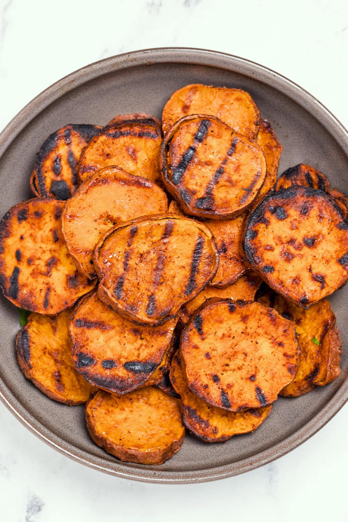 A plate of grilled sweet potatoes on a table.