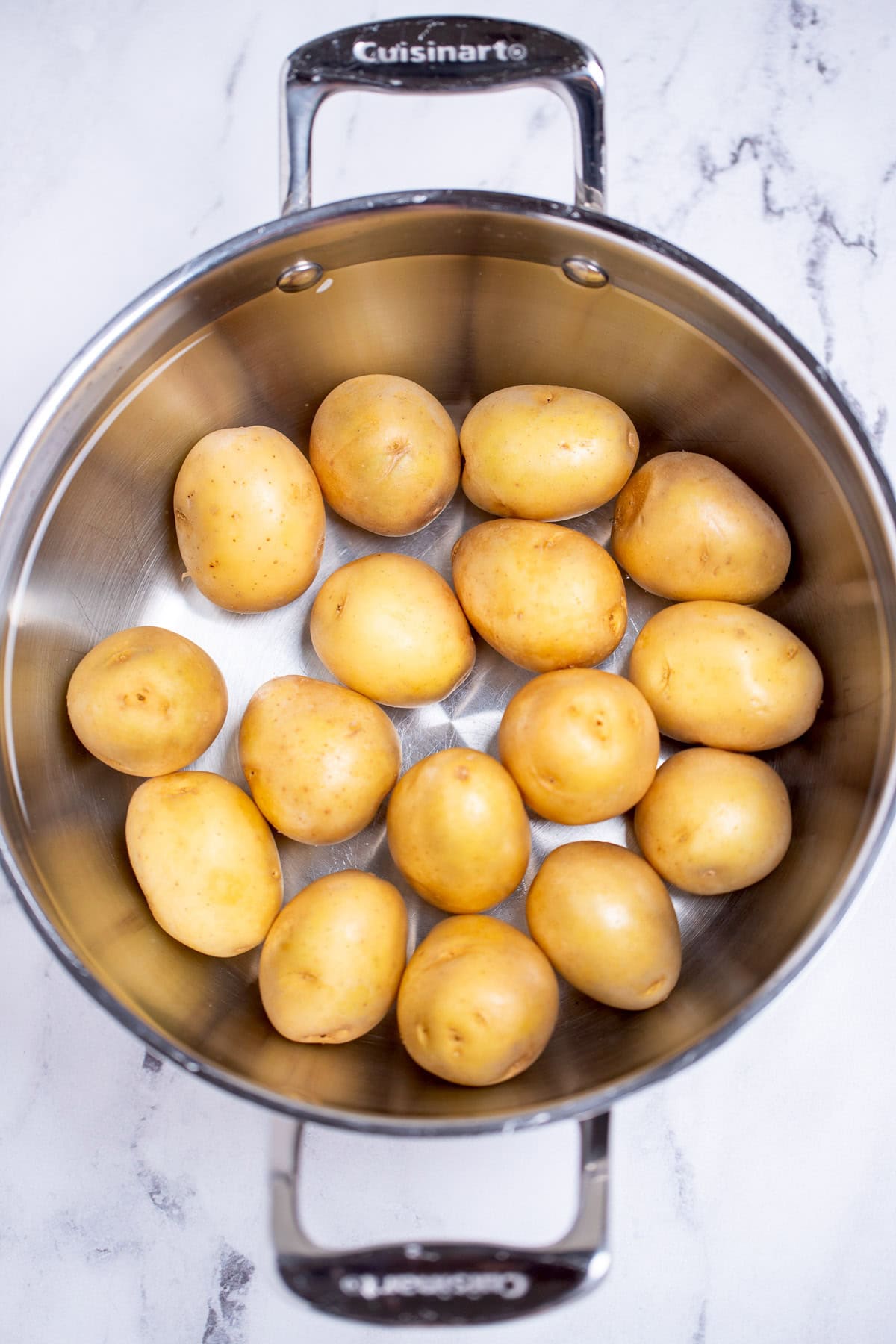 A pot with baby potatoes covered in water.