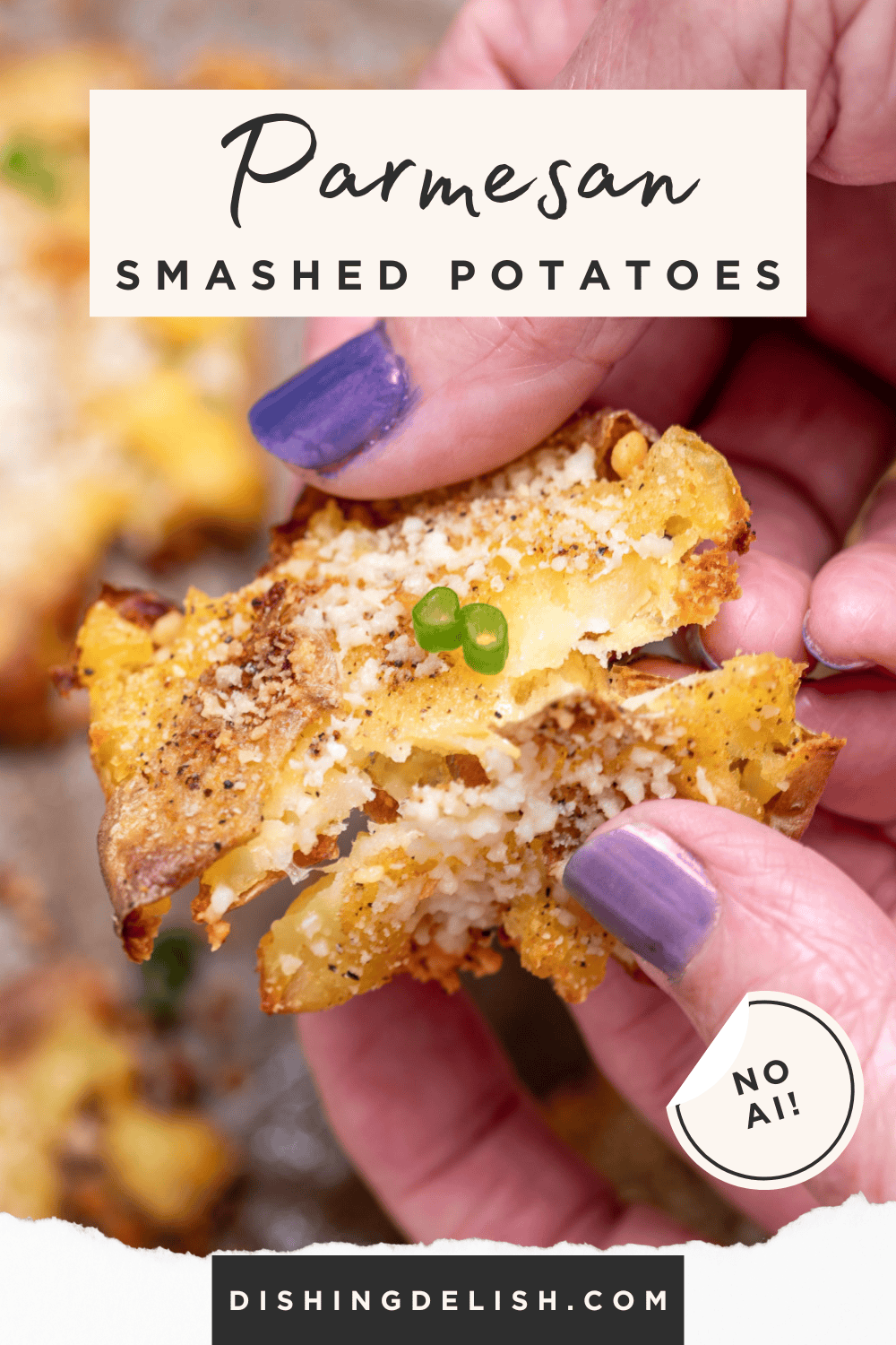 Pinterest pin with two hands holding a garlic parmesan smashed potato while breaking it in half.