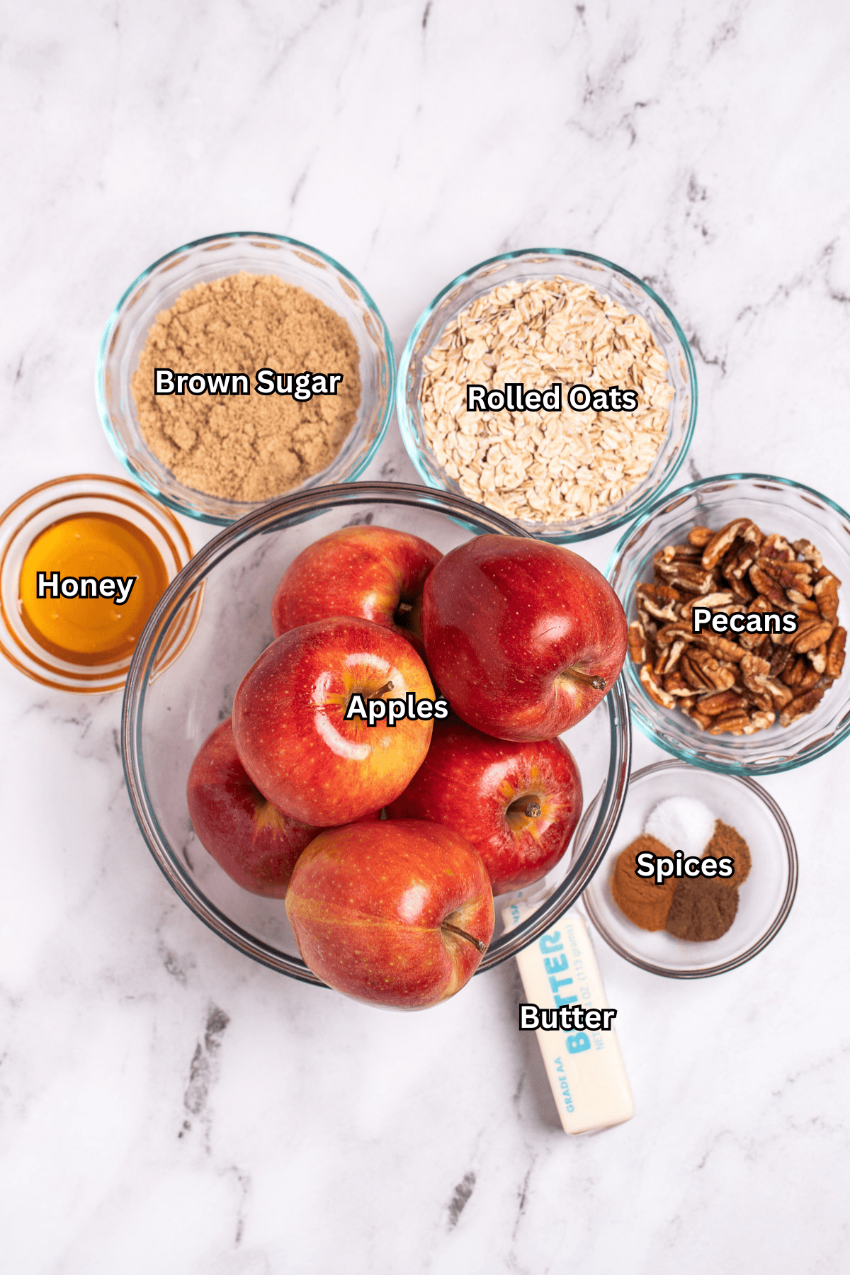 Individual ingredients for baked apples with oatmeal and cinnamon on a table.