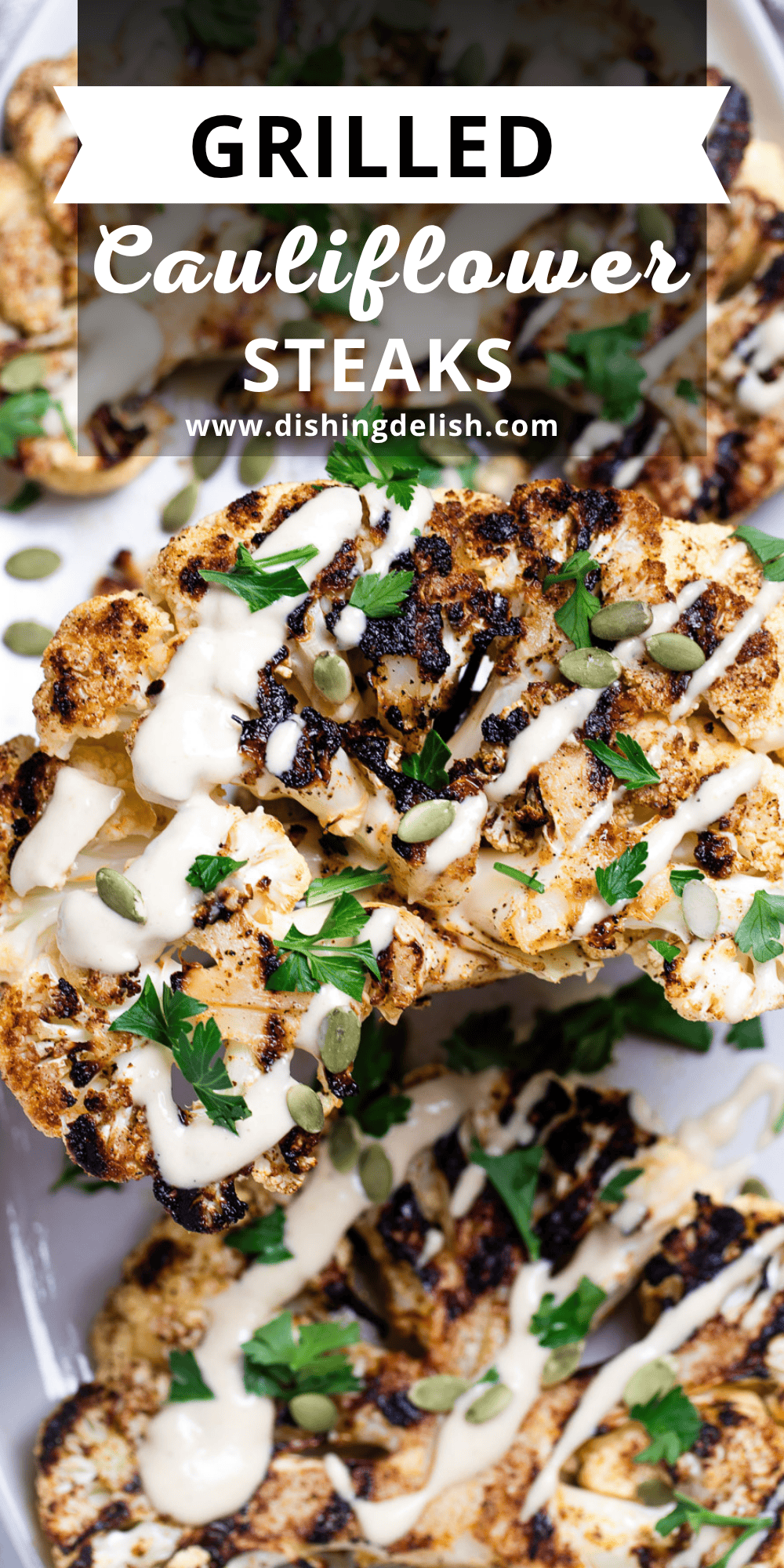 Pinterest pin with Cauliflower steaks on a serving dish, topped with drizzled tahini dressing, fresh parsley, and pumpkin seeds, with a spatula lifting one up.