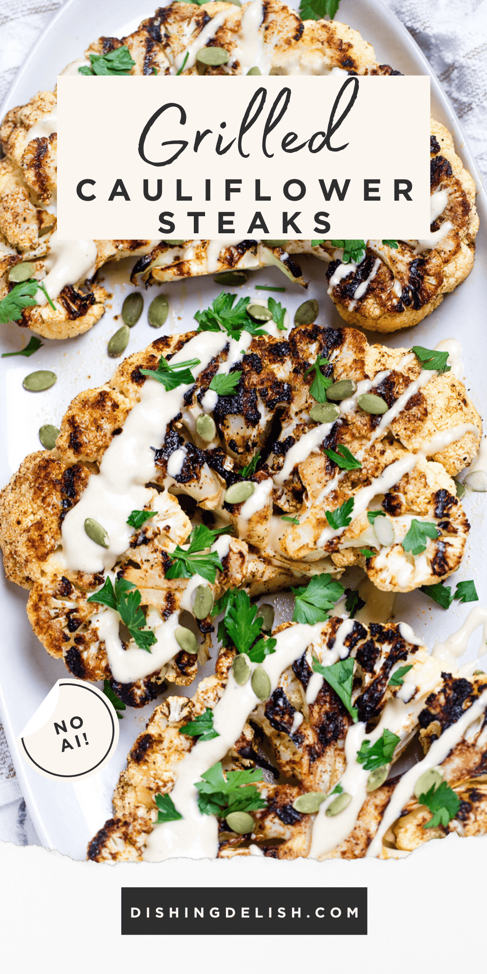 Pinterest pin with Cauliflower steaks on a serving dish, topped with drizzled tahini dressing, fresh parsley, and pumpkin seeds.