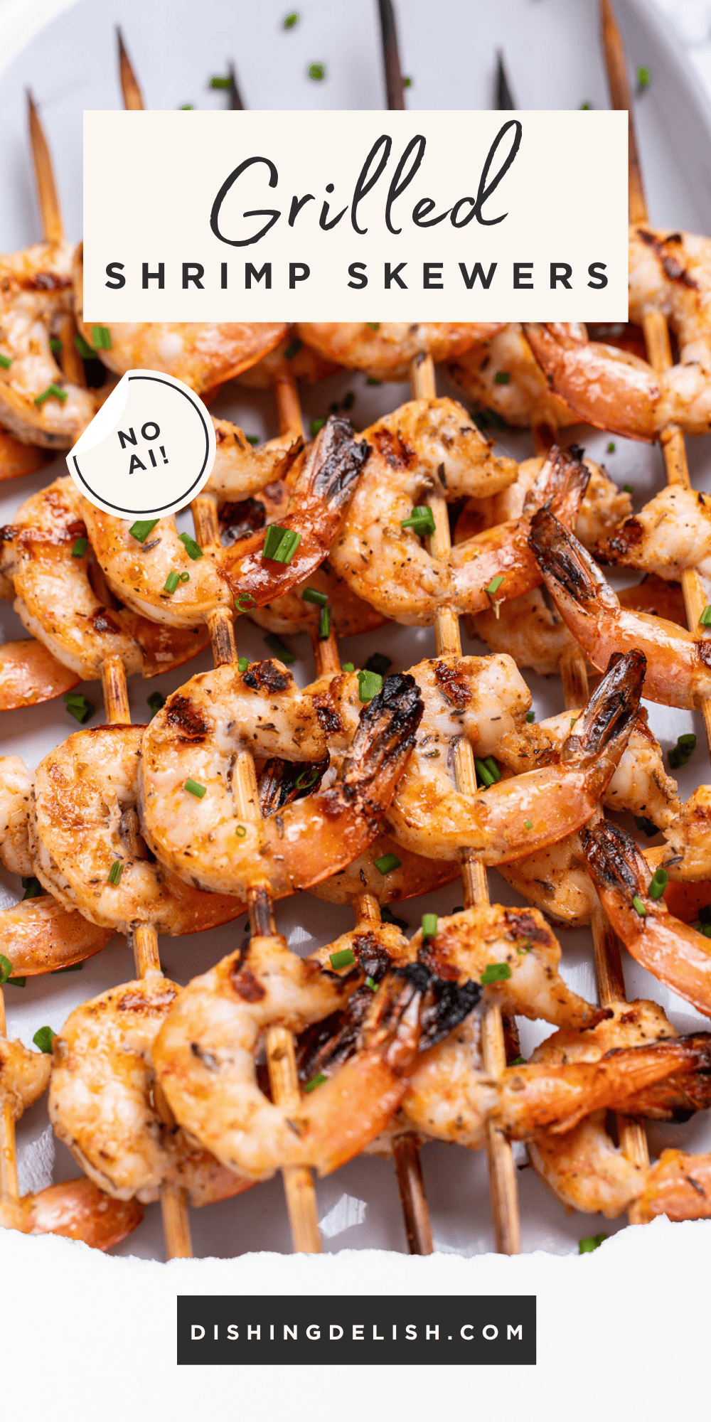 Pinterest pin with a plate on a table with grilled shrimp skewers topped with green onion.