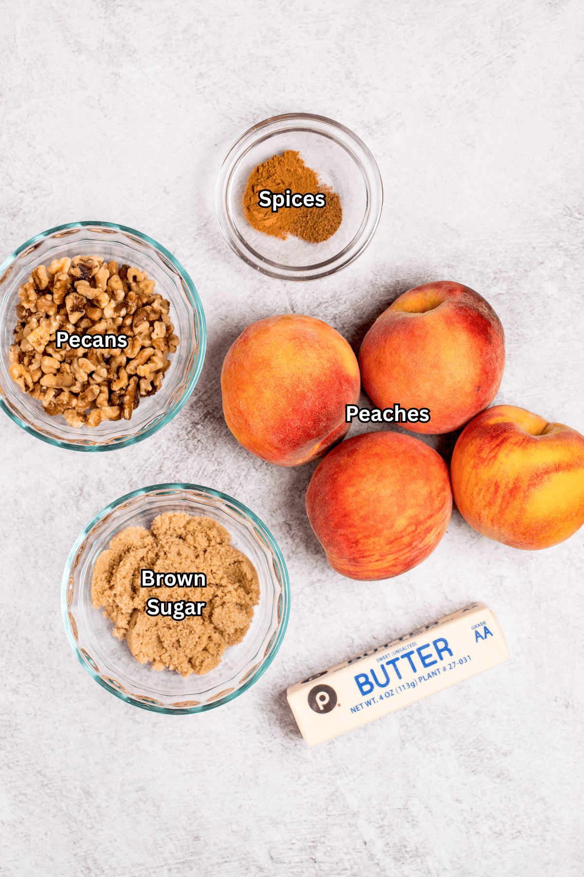 Individual ingredients for baked peaches on a table.