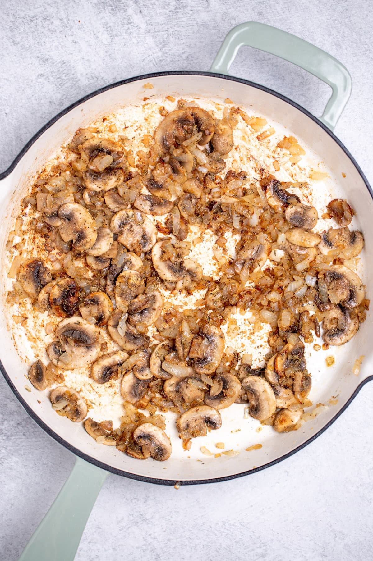 A skillet with sautéed mushrooms, onions, and spices.