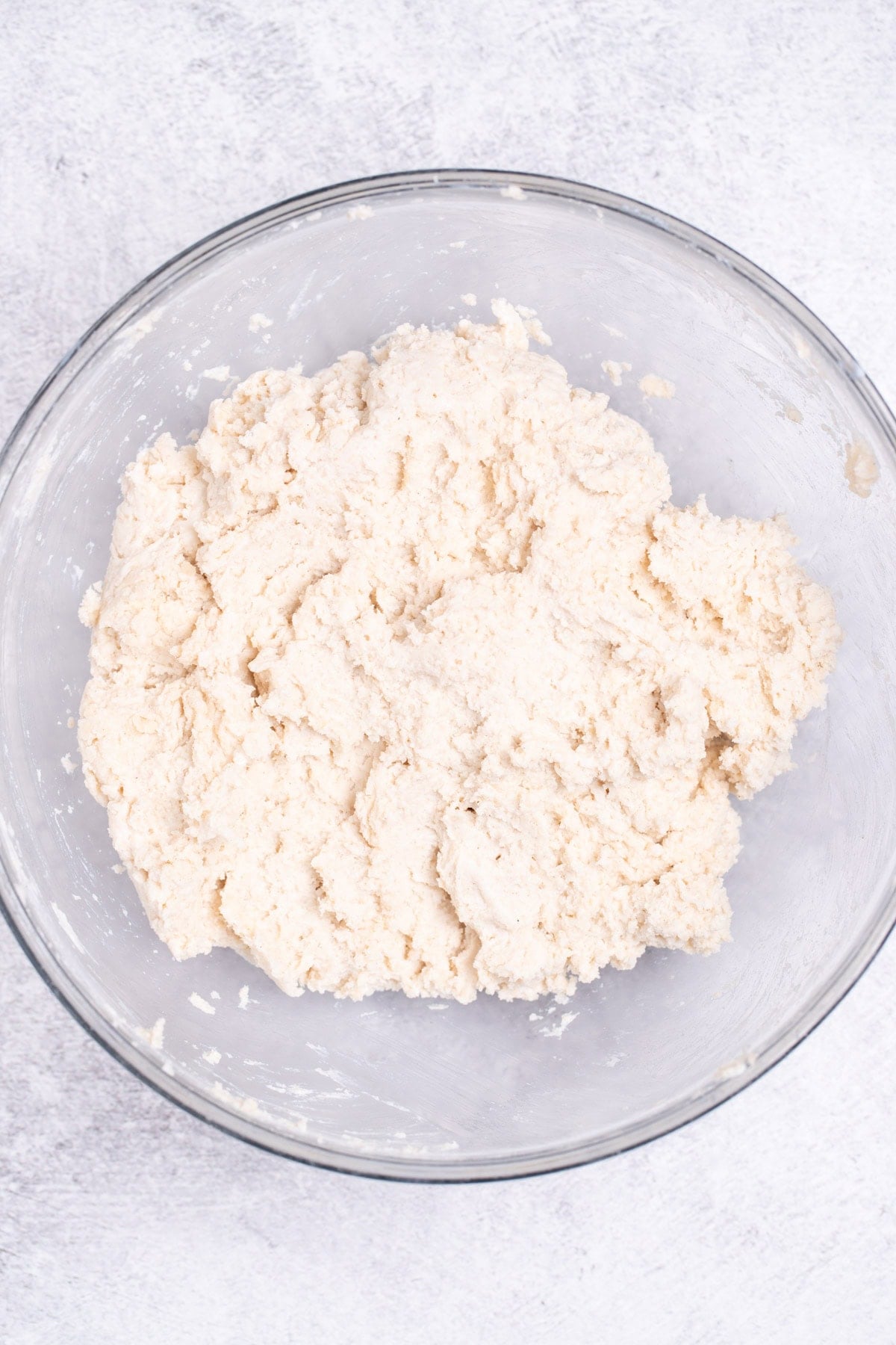 A mixing bowl on a table, with drop biscuit dough ready to be scooped.