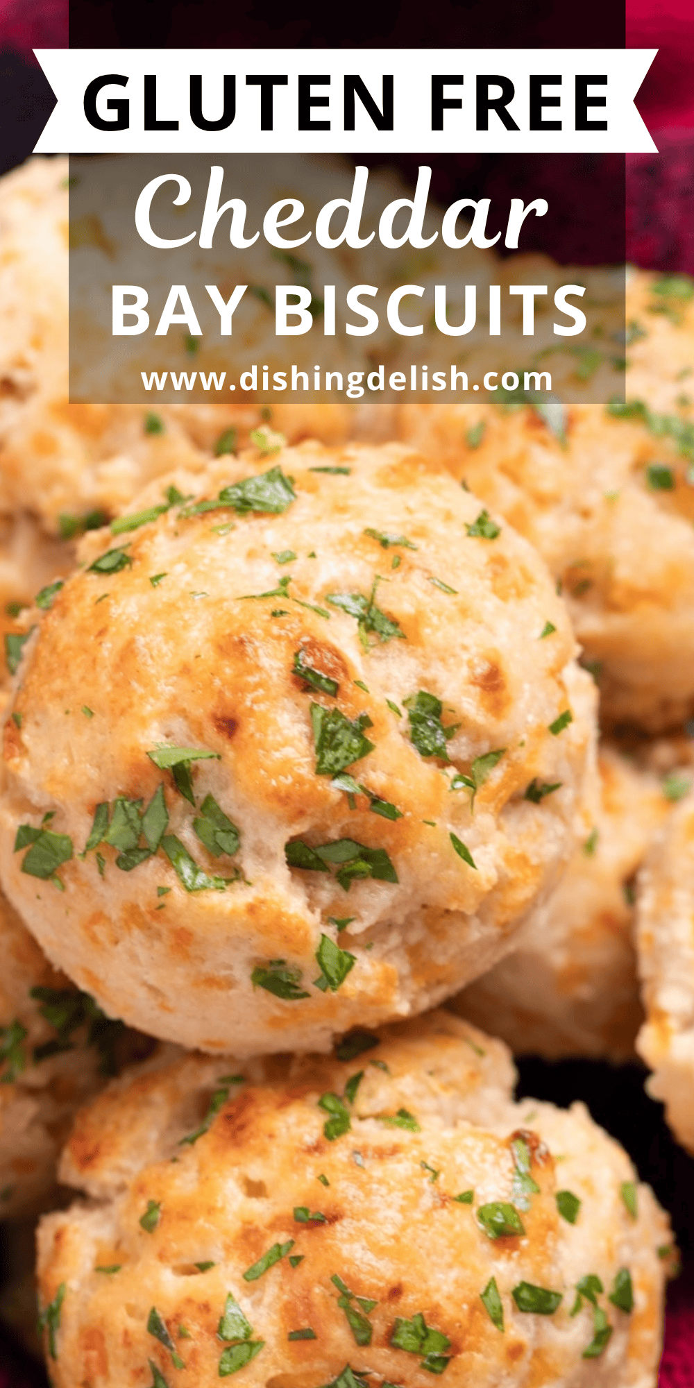 Pinterest pin with copycat Red Lobster cheddar bay biscuits piled on top of each other, topped with fresh parsley and butter.