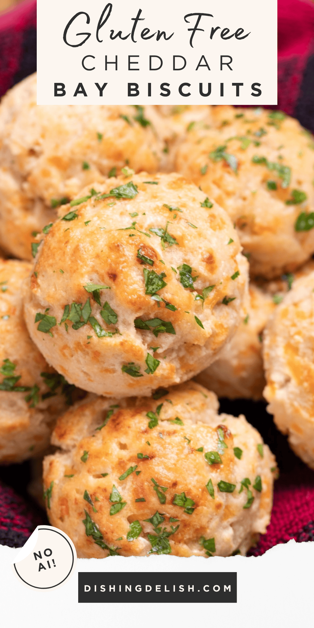 Pinterest pin with a tea towel in a basket, filled with buttery cheddar bay biscuits topped with fresh parsley.