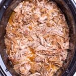 A slow cooker full of shredded apple cider pulled pork.