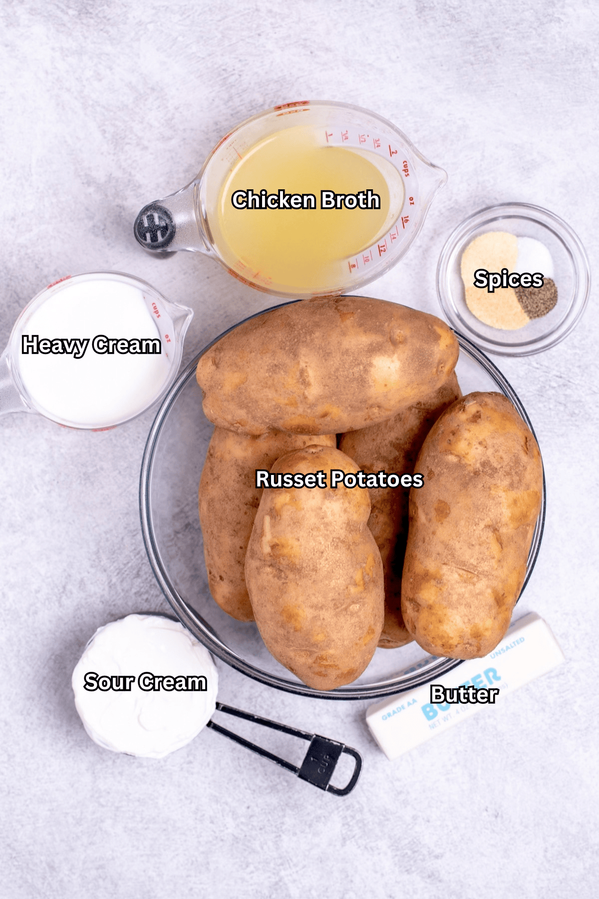 Individual ingredients for slow cooker mashed potatoes on a table.